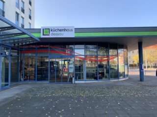 Eingangsbereich Küchenhaus Dessau – Markante Außenwerbung und Fensterbeklebung Der Eingangsbereich des Küchenhaus Dessau zeigt eine auffällige Außenwerbung mit großflächigen Schildern und beklebten Fenstern, die die Marke sichtbar und einladend präsentieren.