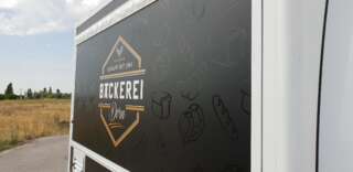 Großflächige seitliche Bedruckung am Fahrzeug der Bäckerei Dorn mit elegantem Logo, feinen Details und klarer Gestaltung.